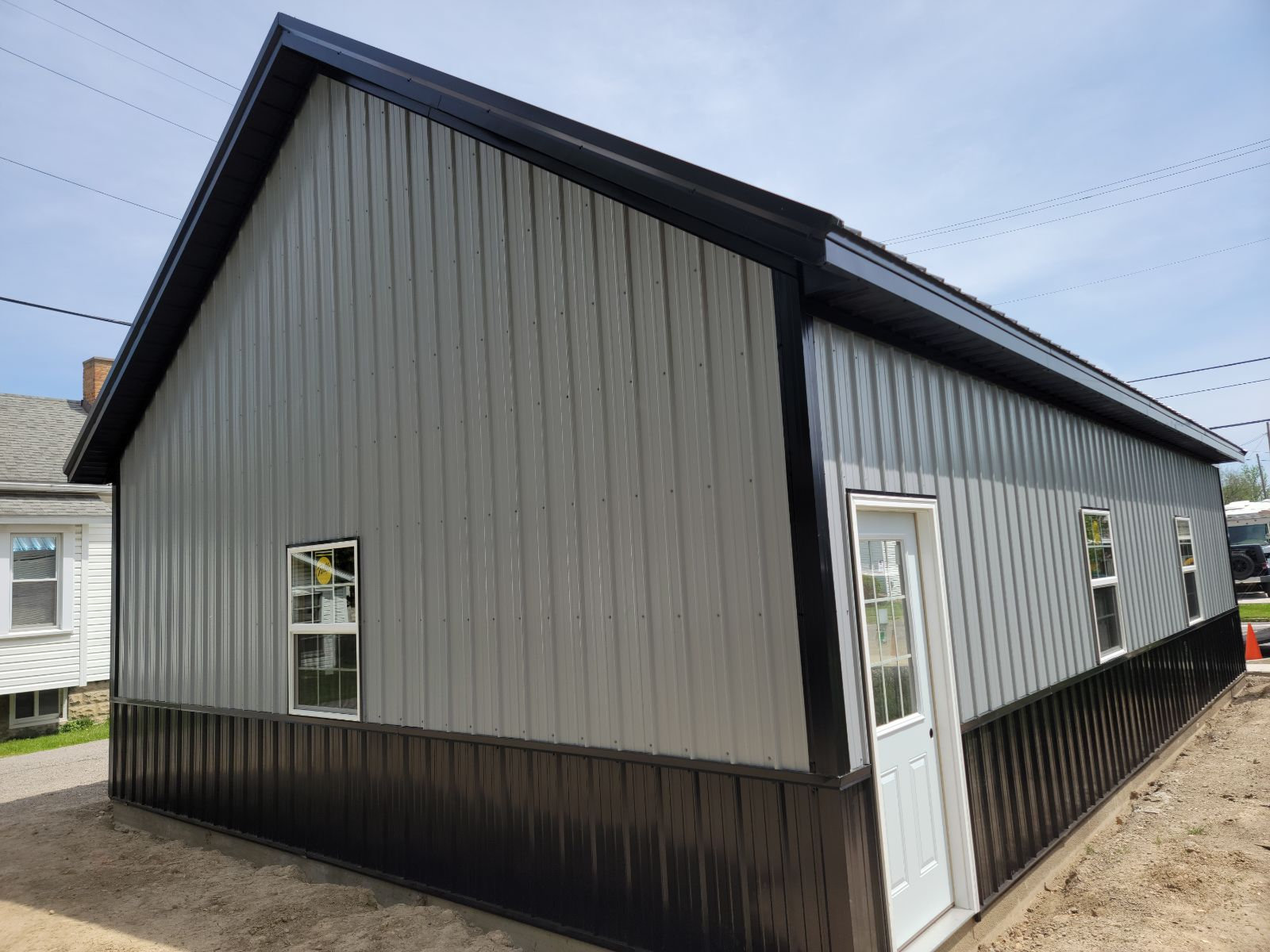 Gray metal sided pole building with black trim completed by T&J Construction