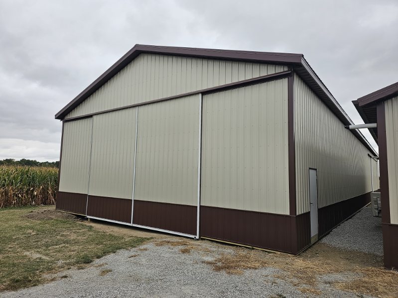 Large tan pole barn with brown wainscot and sliding doors built in Northern Indiana
