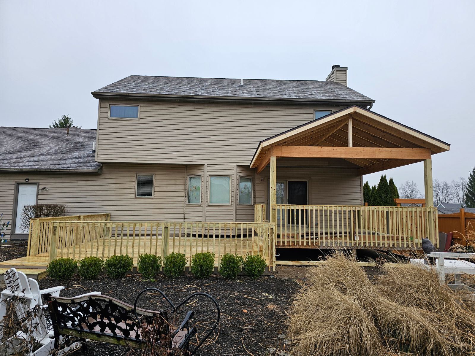 Covered back porch addition with accessible wood ramp and railing