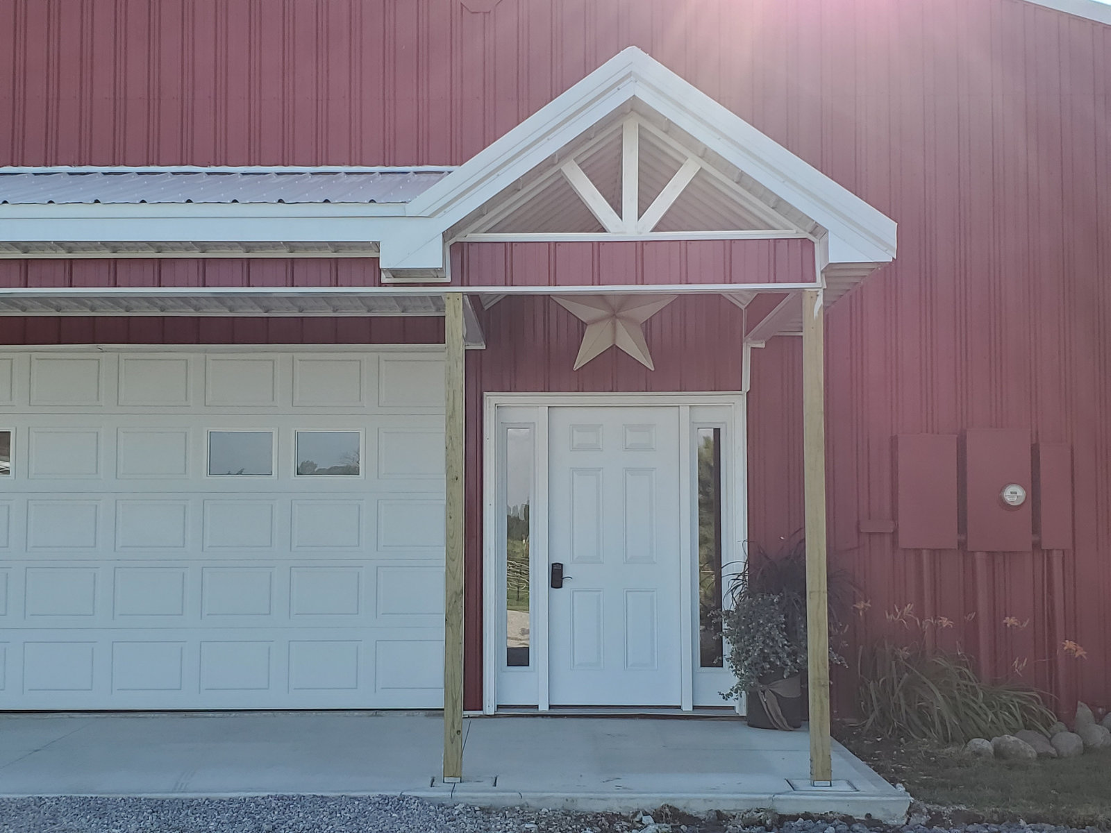 Red pole barn with overhead garage door and covered entry built in Northern Indiana