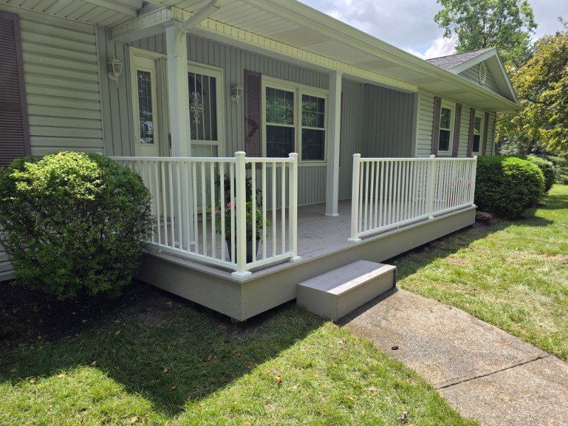 Covered front porch with white spindle railing and composite floor in Northern Indiana