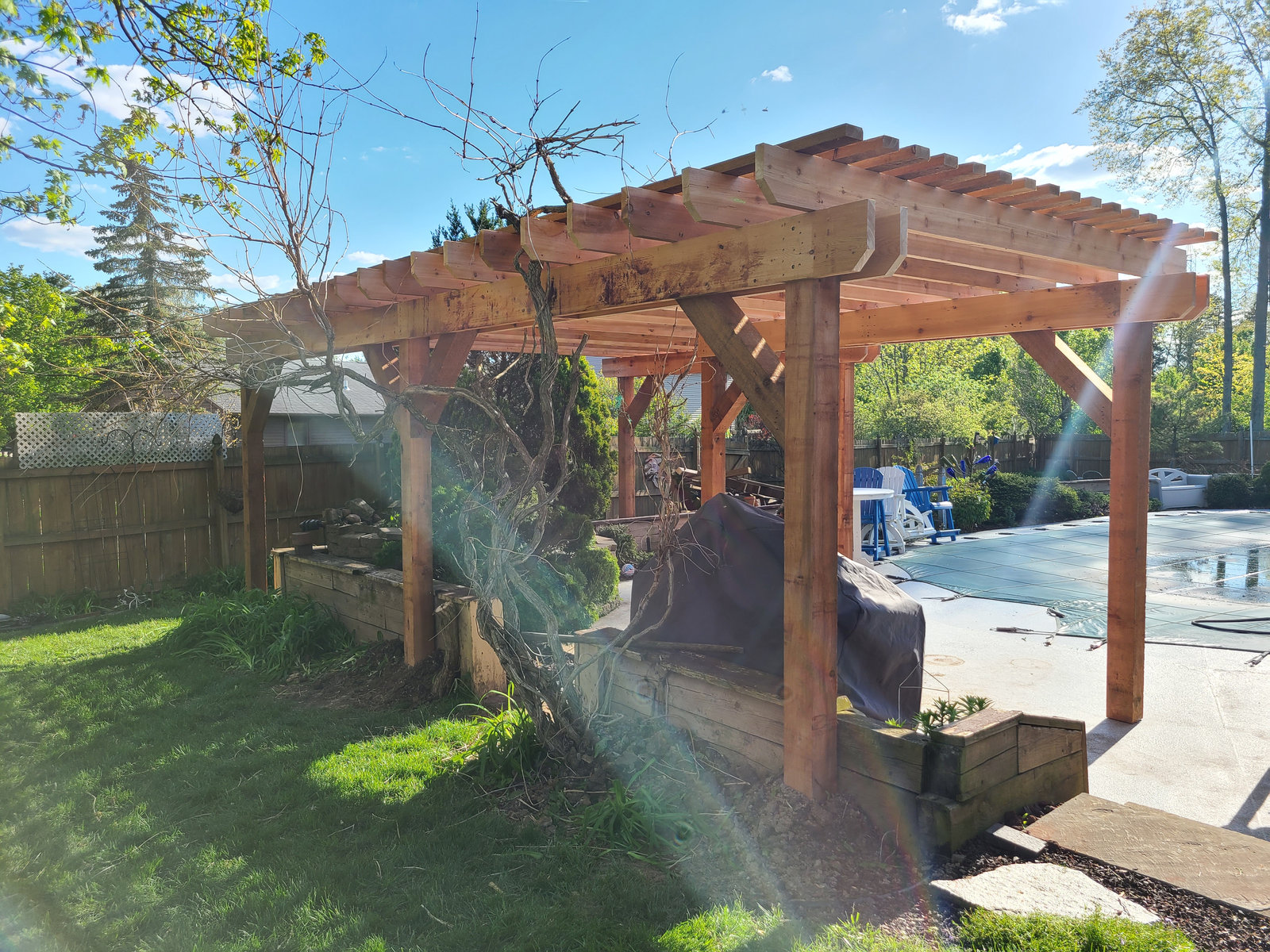 Custom cedar pergola built beside an in ground pool