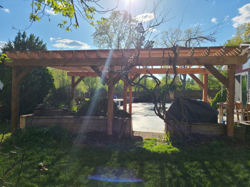 Custom cedar pergola with raised garden beds built by T&J Construction