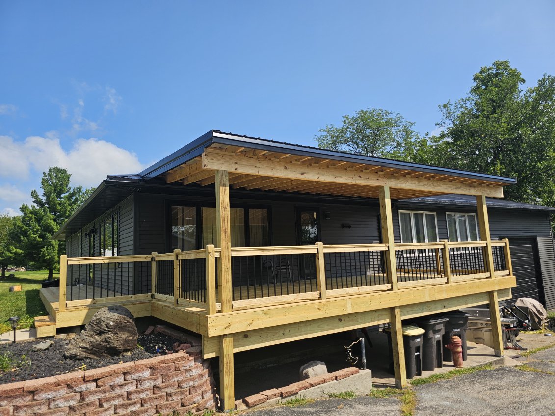 Covered pressure treated deck with wood columns and black metal balusters