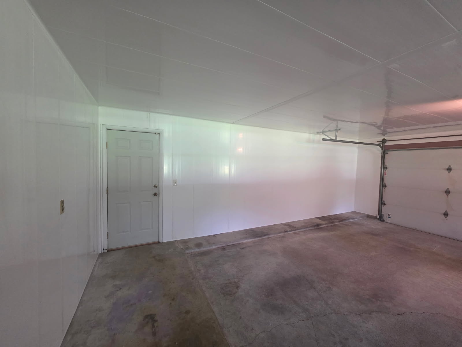 Finished garage interior with bright white insulated wall and ceiling panels