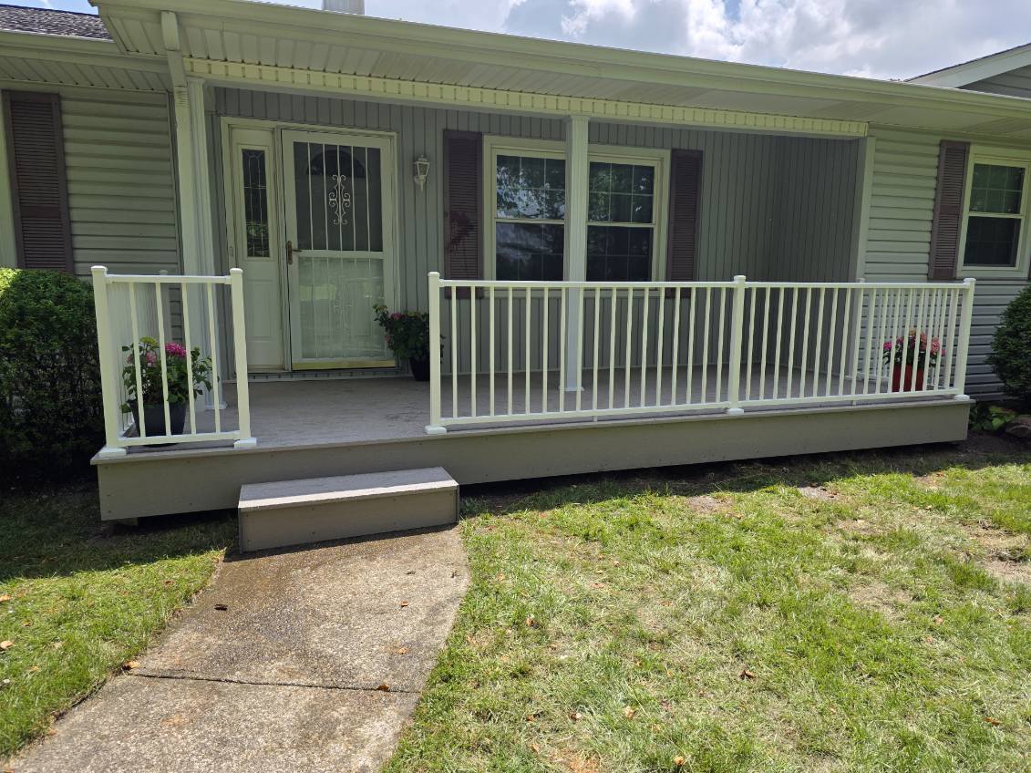 Wide covered front porch with white aluminum railing and painted columns