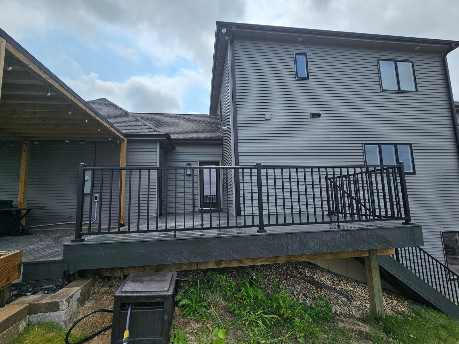 Covered composite deck with black aluminum railing built by T&J Construction