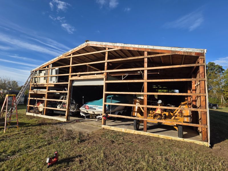 Pole barn siding replacement project with existing frame exposed for new metal siding
