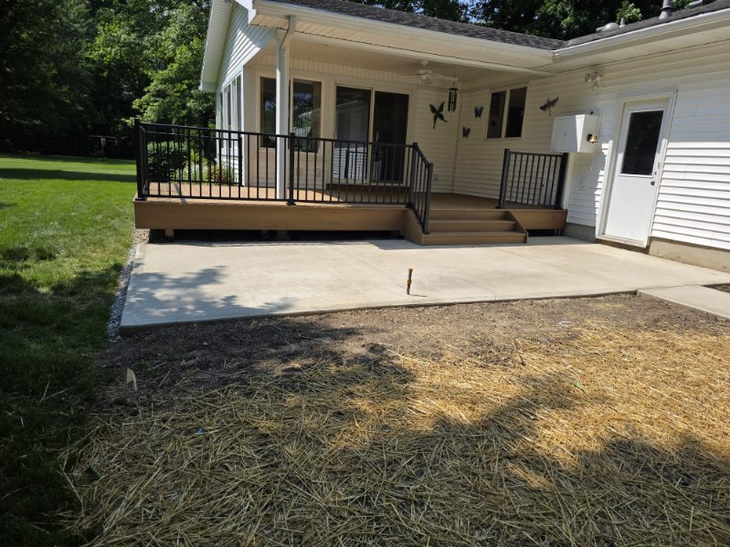 Low profile composite deck with black aluminum railing and concrete patio extension