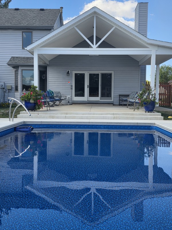 Custom gable roof pool pavilion attached to a two story home with in-ground pool