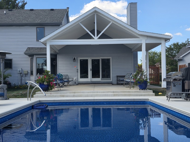 Covered poolside porch pavilion with vaulted white ceiling and decorative gable trusses built by a Northern Indiana porch builder